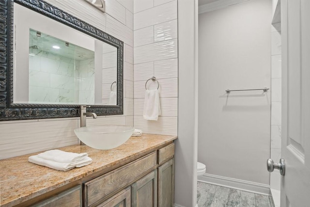 bathroom featuring hardwood / wood-style floors, vanity, toilet, and backsplash