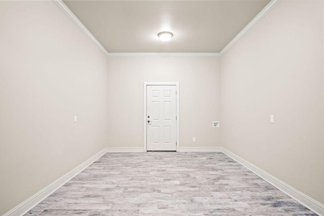 empty room featuring light hardwood / wood-style floors and crown molding