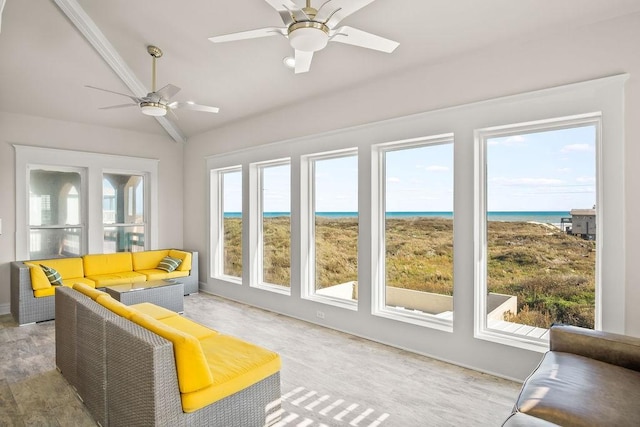 sunroom / solarium with a wealth of natural light, a water view, vaulted ceiling, and ceiling fan