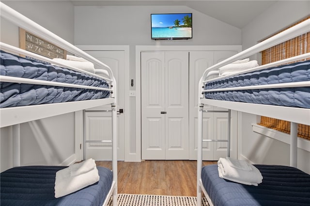 bedroom with lofted ceiling and light hardwood / wood-style floors