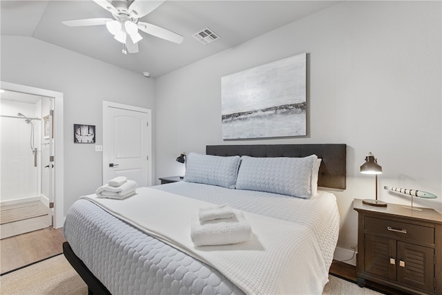 bedroom featuring ensuite bathroom, ceiling fan, light wood-type flooring, and lofted ceiling