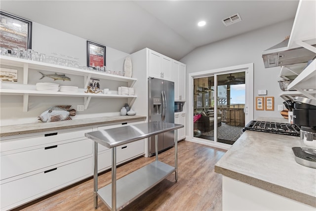 kitchen with white cabinetry, light hardwood / wood-style floors, lofted ceiling, and stainless steel fridge with ice dispenser