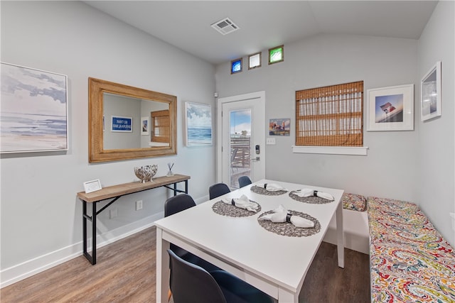 dining room with hardwood / wood-style floors and vaulted ceiling