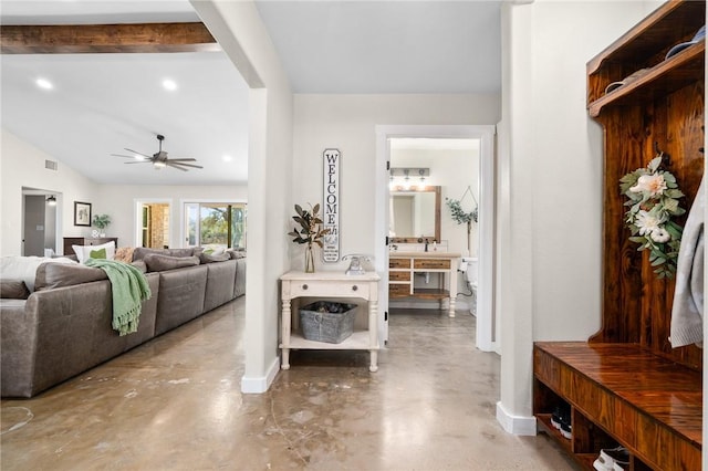 entrance foyer featuring concrete flooring, vaulted ceiling with beams, and ceiling fan