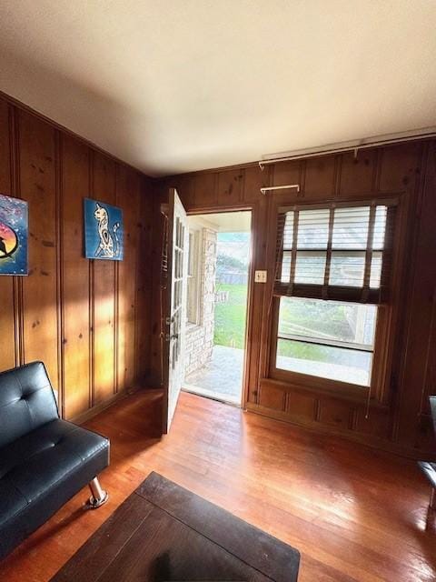 doorway with light wood-style floors and wood walls