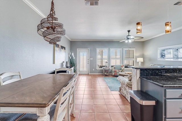 interior space with decorative light fixtures, light tile patterned floors, ceiling fan, and crown molding