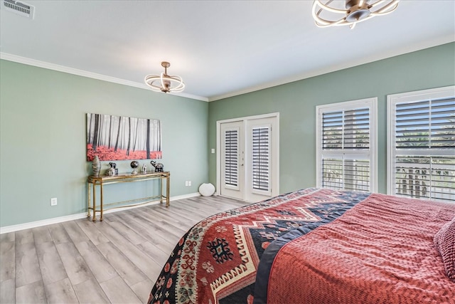 bedroom featuring access to outside, french doors, crown molding, light wood-type flooring, and an inviting chandelier