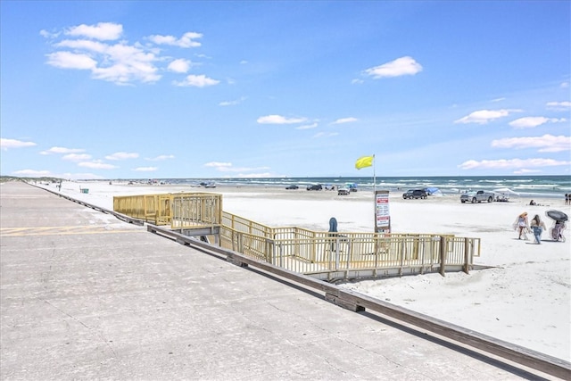 view of property's community featuring a water view and a beach view