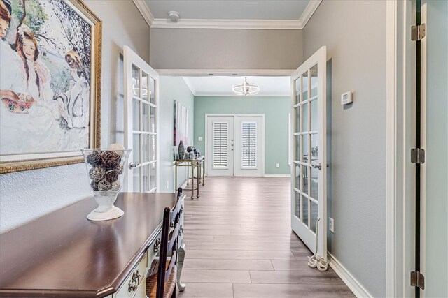 hallway with hardwood / wood-style flooring, french doors, and ornamental molding