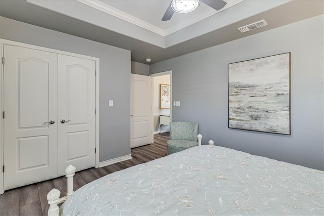 bedroom with ceiling fan, dark hardwood / wood-style floors, a closet, and crown molding