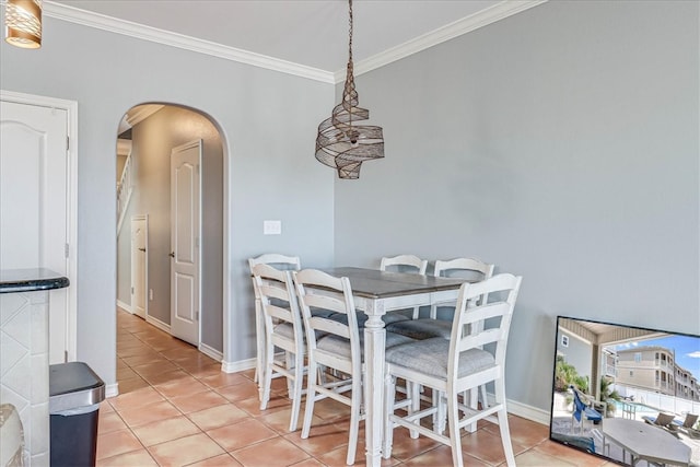 tiled dining room featuring crown molding