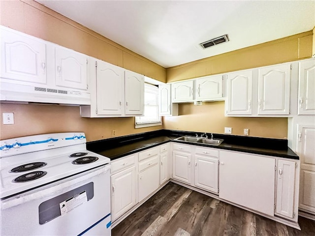 kitchen with white electric range, dark countertops, visible vents, and under cabinet range hood