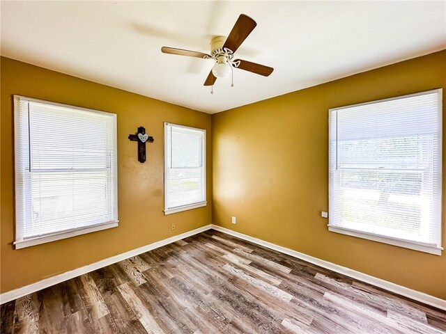 unfurnished room with wood finished floors, ceiling fan, and baseboards