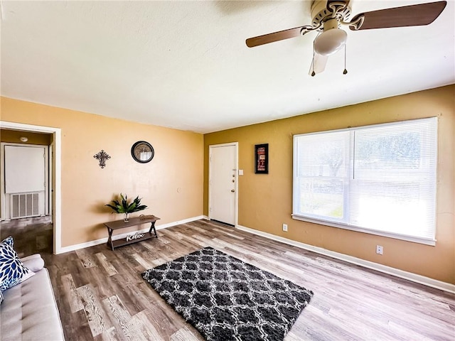 foyer featuring ceiling fan, visible vents, baseboards, and wood finished floors