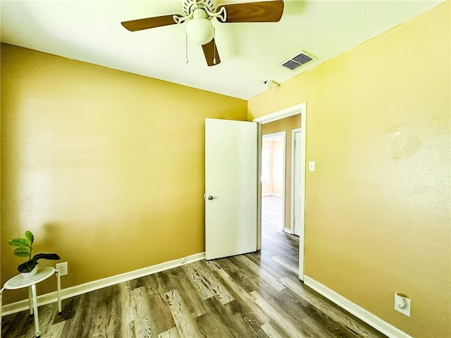 empty room with visible vents, baseboards, ceiling fan, and wood finished floors