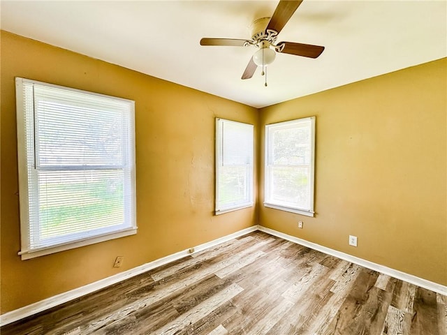 unfurnished room with baseboards, a ceiling fan, and wood finished floors