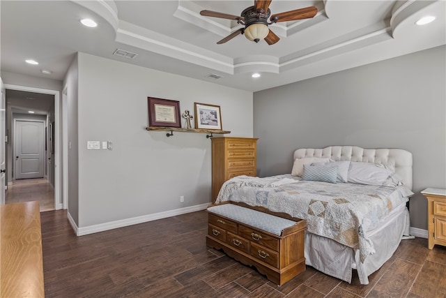 bedroom with ceiling fan, a raised ceiling, and dark hardwood / wood-style flooring