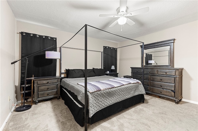 carpeted bedroom featuring ceiling fan and a textured ceiling