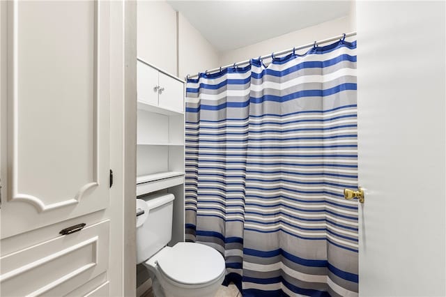 bathroom featuring toilet and walk in shower