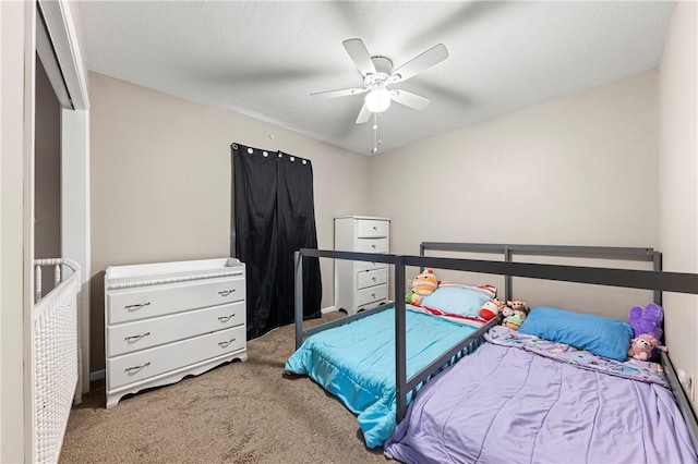 carpeted bedroom featuring a textured ceiling and ceiling fan