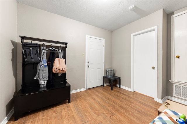 mudroom with a textured ceiling and light hardwood / wood-style floors