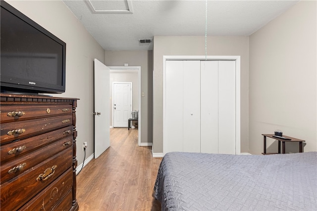 bedroom featuring a closet, a textured ceiling, and light wood-type flooring