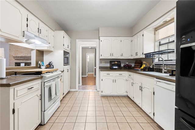 kitchen featuring white cabinetry, white appliances, sink, and light tile patterned floors