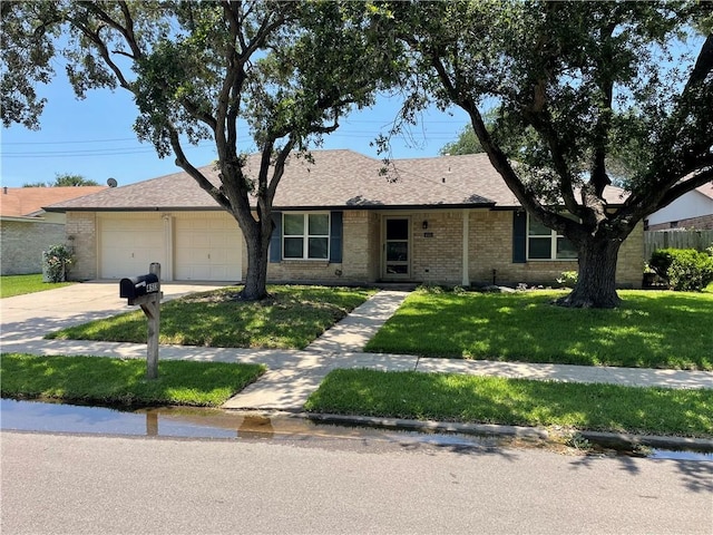 4513 Snead Dr, Corpus Christi, TX 78413 - ranch-style home with concrete driveway, a front yard, an attached garage, brick siding, and roof with shingles