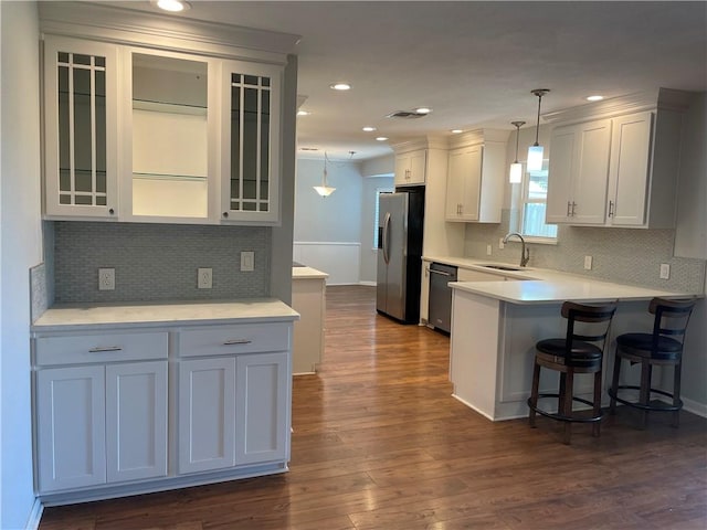 4513 Snead Dr, Corpus Christi, TX 78413 - kitchen featuring stainless steel appliances, a breakfast bar, glass insert cabinets, a peninsula, and light countertops