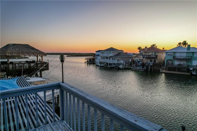 view of dock featuring a water view, a gazebo, a residential view, and a balcony