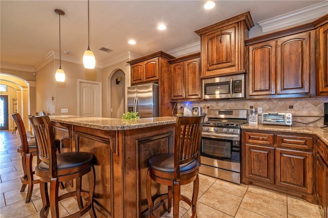 3918 Willow Heights Dr, Corpus Christi, TX 78410 - kitchen featuring appliances with stainless steel finishes, a breakfast bar area, ornamental molding, backsplash, and hanging light fixtures