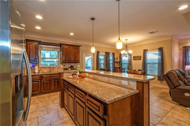 3918 Willow Heights Dr, Corpus Christi, TX 78410 - kitchen featuring stainless steel fridge, a kitchen island, open floor plan, healthy amount of natural light, and crown molding