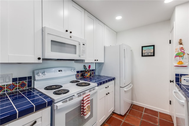 kitchen featuring tile countertops, white cabinetry, and white appliances