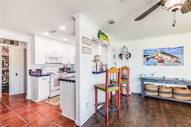 kitchen featuring ornamental molding, white appliances, ceiling fan, white cabinets, and dark hardwood / wood-style floors