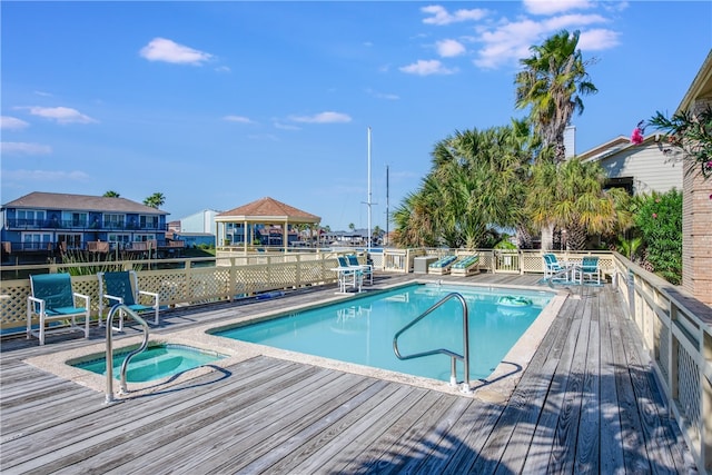 view of pool featuring a wooden deck and an in ground hot tub