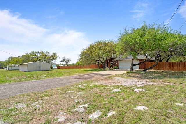 2214 N Mccampbell St, Aransas Pass, TX 78336 - view of yard with driveway, an attached garage, and an outdoor structure
