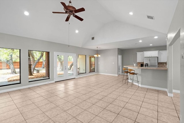2214 N Mccampbell St, Aransas Pass, TX 78336 - unfurnished living room with high vaulted ceiling, recessed lighting, a ceiling fan, light tile patterned flooring, and a chandelier
