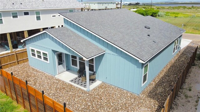 1931 Eskridge St, Port Aransas, TX 78373 - rear view of house with a shingled roof, board and batten siding, and a fenced backyard