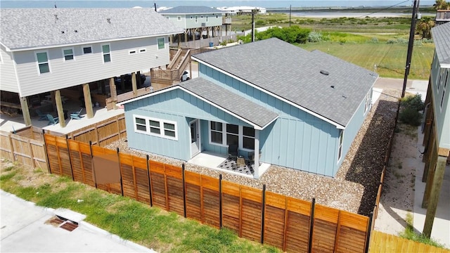 1931 Eskridge St, Port Aransas, TX 78373 - back of house with roof with shingles, a fenced backyard, and board and batten siding