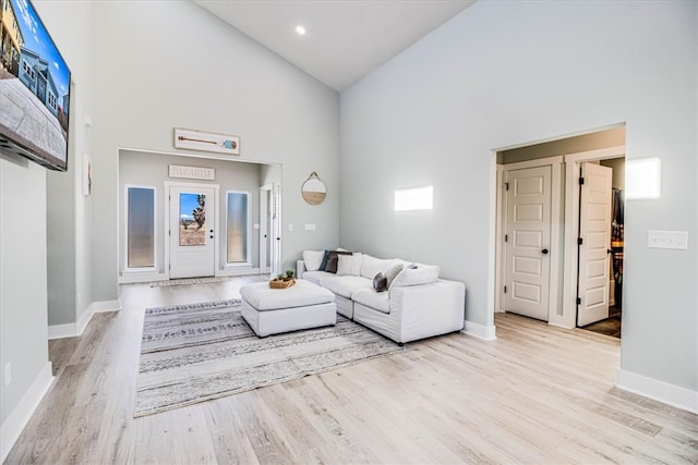 living room featuring baseboards, recessed lighting, high vaulted ceiling, and wood finished floors