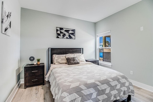 bedroom with light wood finished floors and baseboards