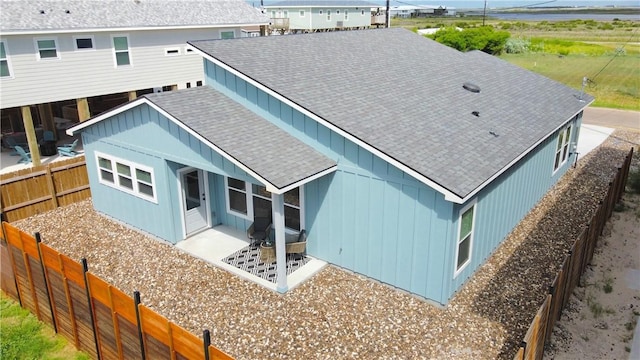 1931 Eskridge St, Port Aransas, TX 78373 - back of house featuring roof with shingles, board and batten siding, and a fenced backyard