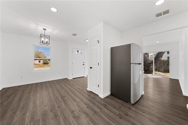 kitchen with dark hardwood / wood-style floors, plenty of natural light, pendant lighting, and stainless steel fridge