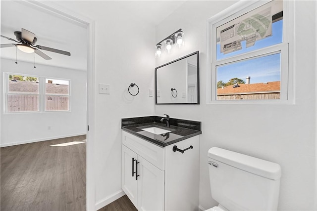 bathroom with ceiling fan, vanity, wood-type flooring, and toilet