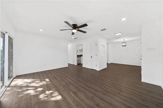 unfurnished living room featuring dark wood-type flooring and ceiling fan with notable chandelier