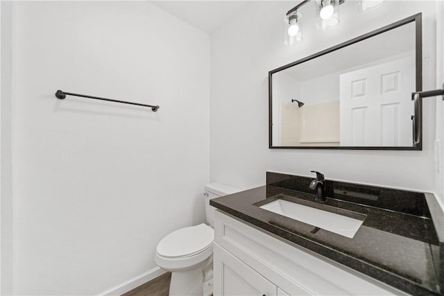 bathroom with toilet, vanity, walk in shower, and hardwood / wood-style floors