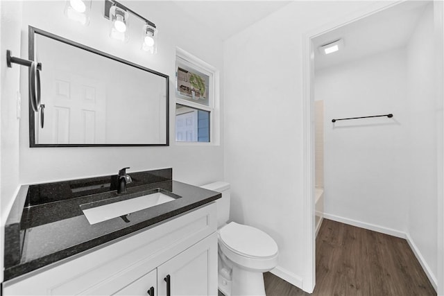 bathroom featuring toilet, vanity, and hardwood / wood-style floors