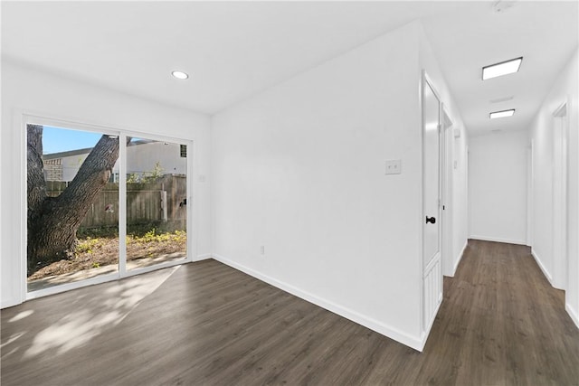 spare room featuring dark hardwood / wood-style flooring and a healthy amount of sunlight