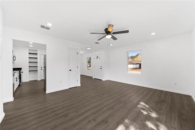 unfurnished living room with dark wood-type flooring, ceiling fan, and a fireplace