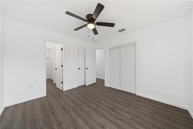 unfurnished bedroom featuring ceiling fan and dark hardwood / wood-style flooring